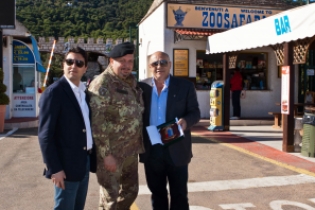 L'Assessore Renzo De Leonardis, il col. Gerardo Pezzuto e il Sindaco Lello Di Bari con lo stemma del reggimento davanti l'ingresso dello ZooSafari di Fasano